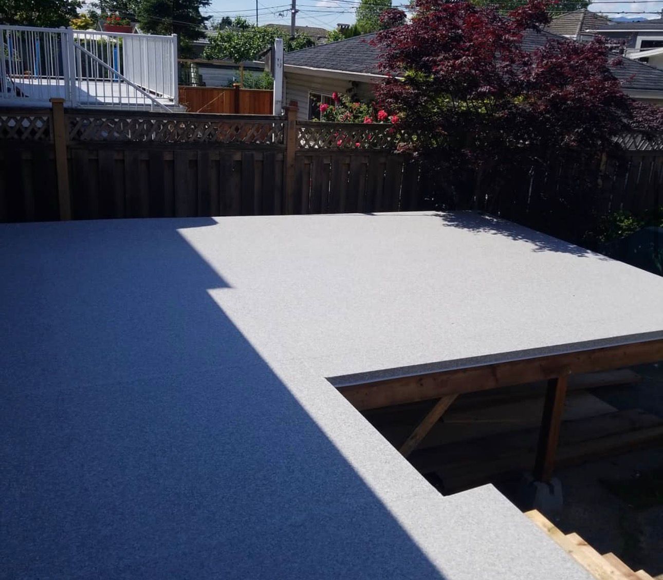Finished low-maintenance vinyl deck in a Calgary backyard surrounded by privacy fencing