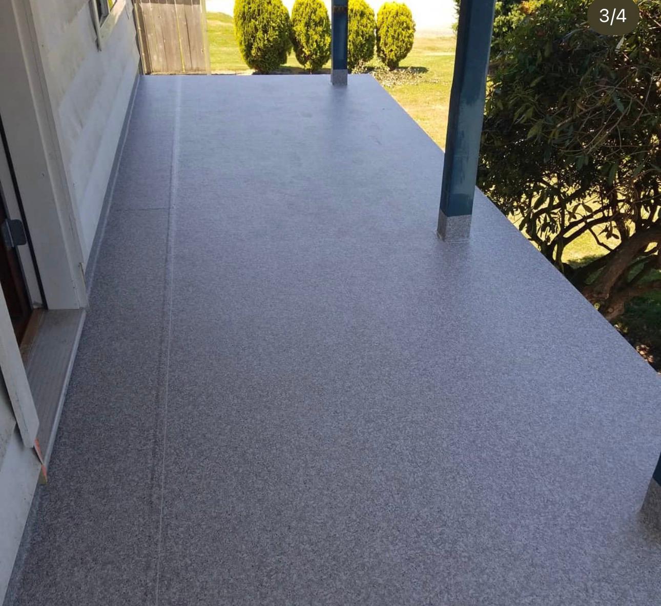 Slip-resistant grey vinyl deck surface installed along the side of a home